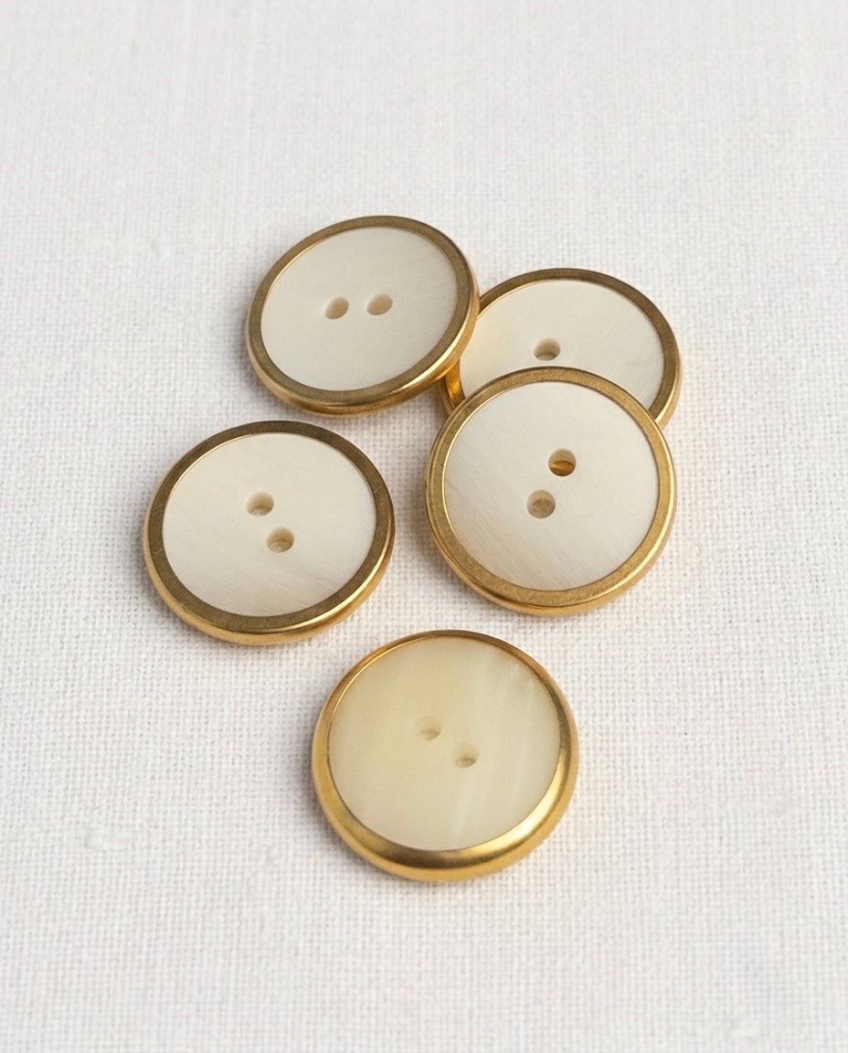 Cinq grands boutons ronds de 22 mm à 2 trous, centre effet corne crème veiné et bord doré, dont un vu de dos