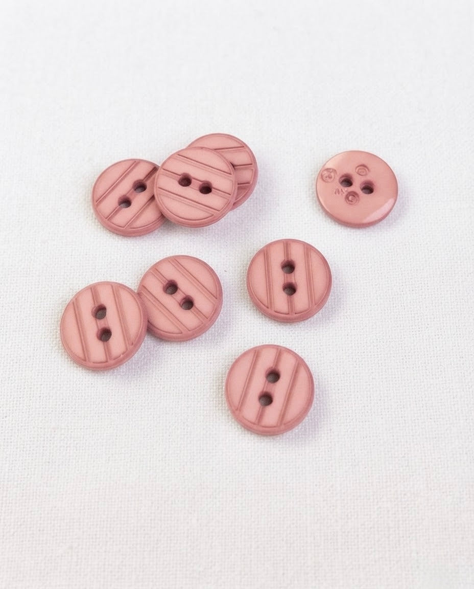 Boutons ronds rose ancien de 13 mm à 2 trous gravés de rainures obliques, posés sur une toile écrue