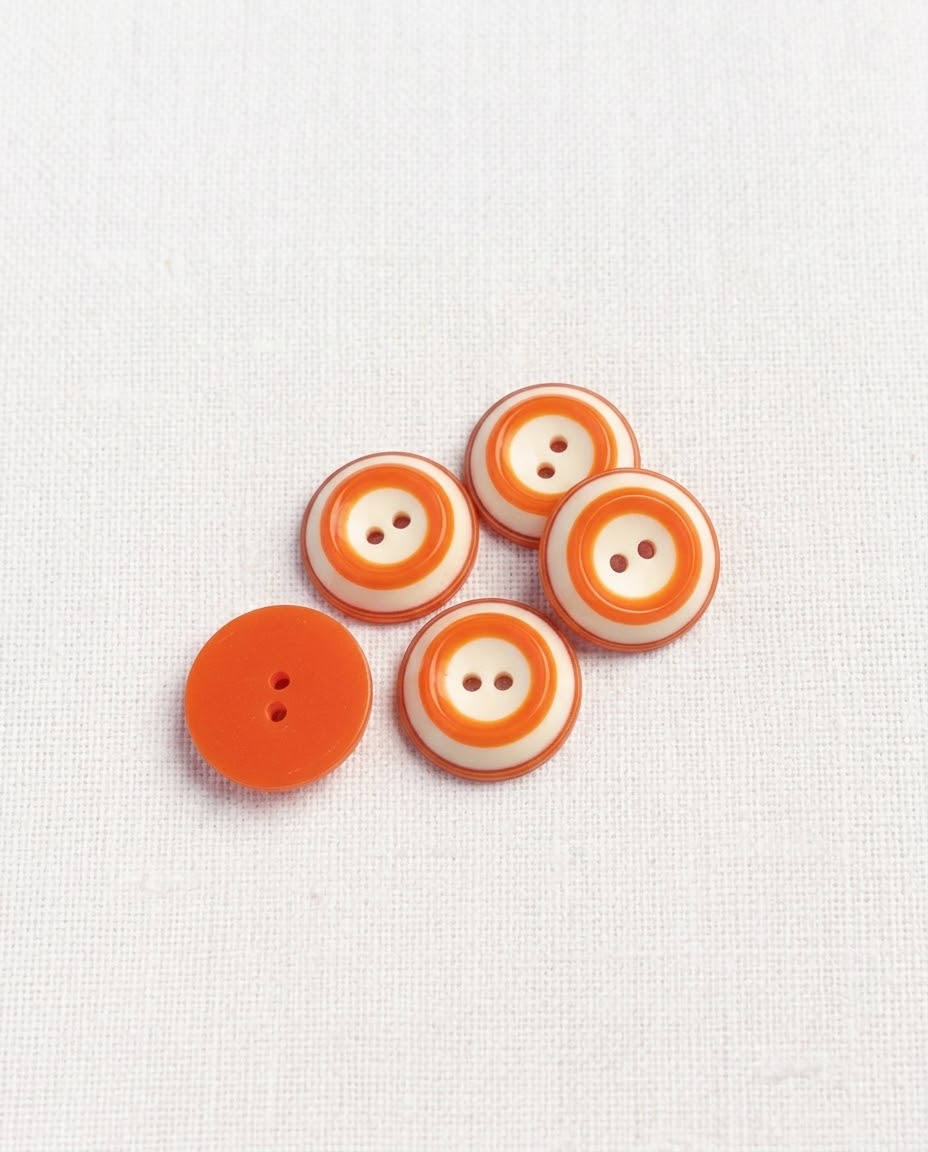 Cinq boutons ronds de 18 mm à 2 trous à cercles orange et crème, dont un vu de dos orange uni