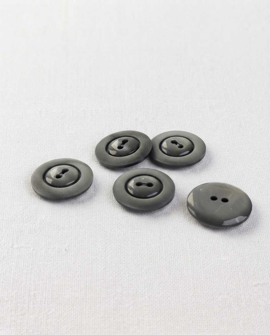 Cinq boutons ronds gris ardoise de 17 mm à 2 trous, large bord mat et centre brillant, dont un vu de dos
