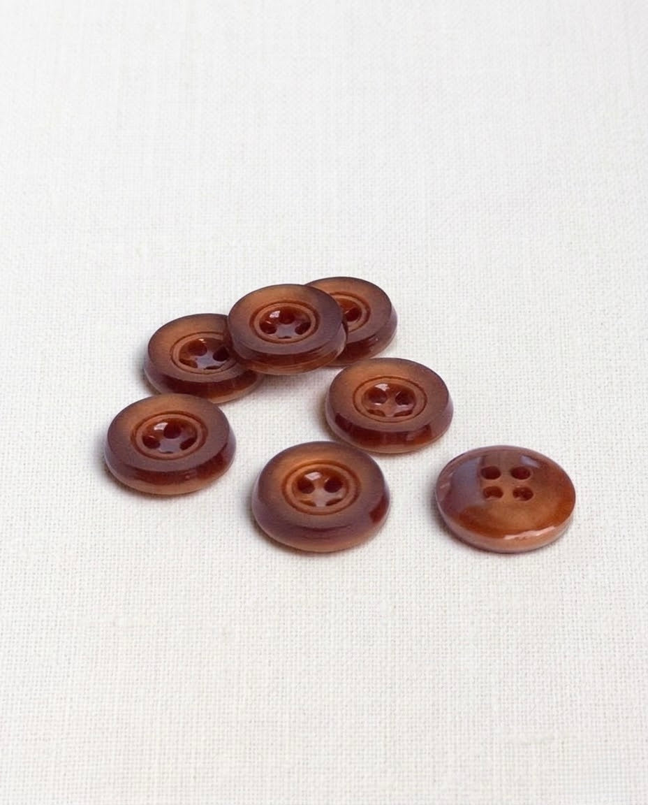 Boutons ronds rouille de 14 mm à 4 trous vus de trois quarts, dont un retourné qui montre son dos
