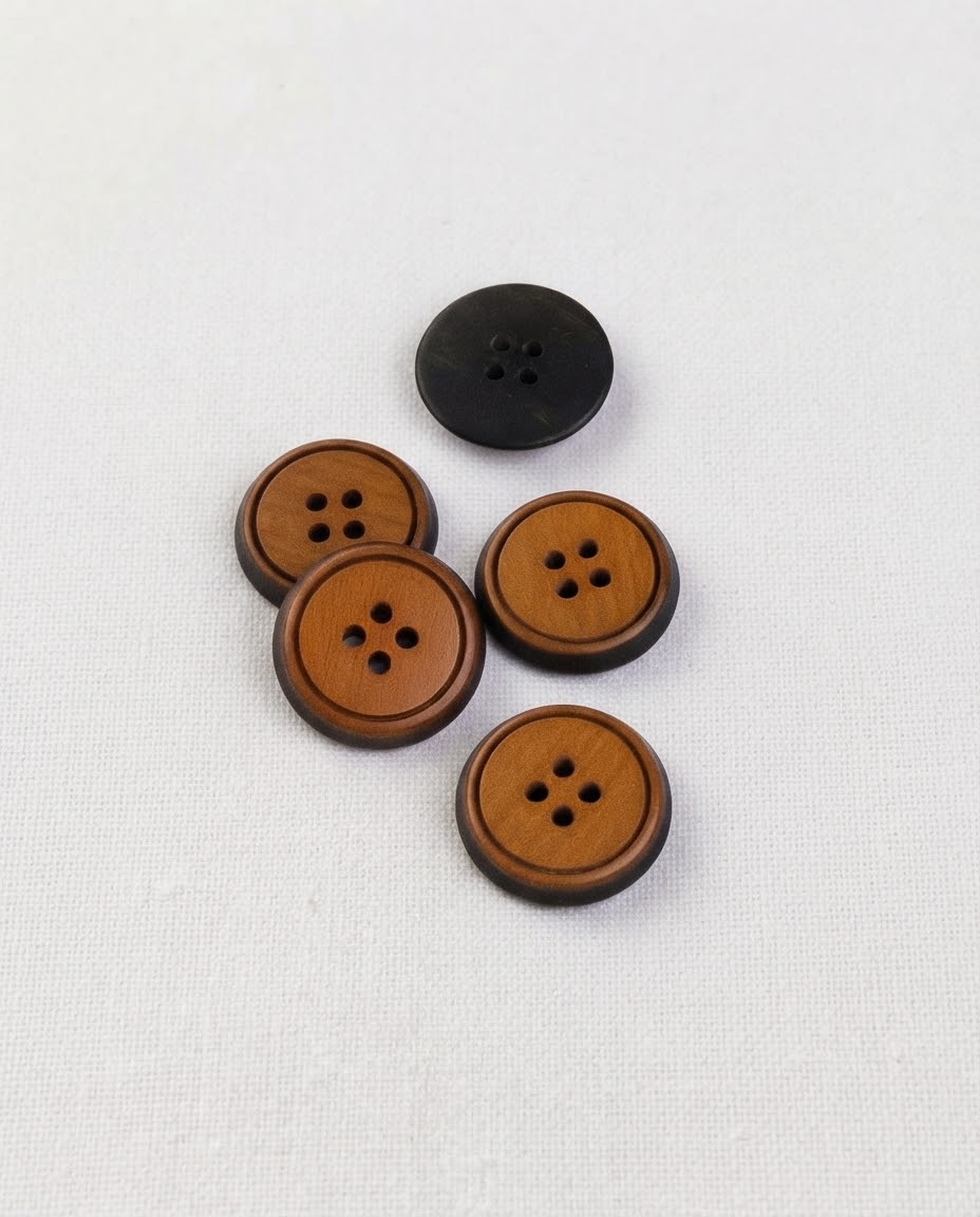 Cinq boutons ronds de 17 mm à 4 trous, centre miel veiné cerné d'un bord brun foncé, dont un vu de dos