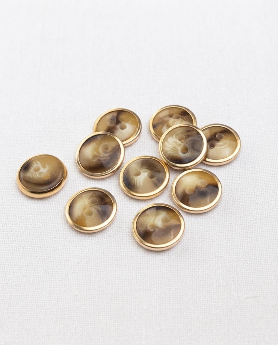 Dix boutons ronds effet corne de 12 mm à 2 trous, volutes miel et brun cerclées de doré, dont un vu de dos