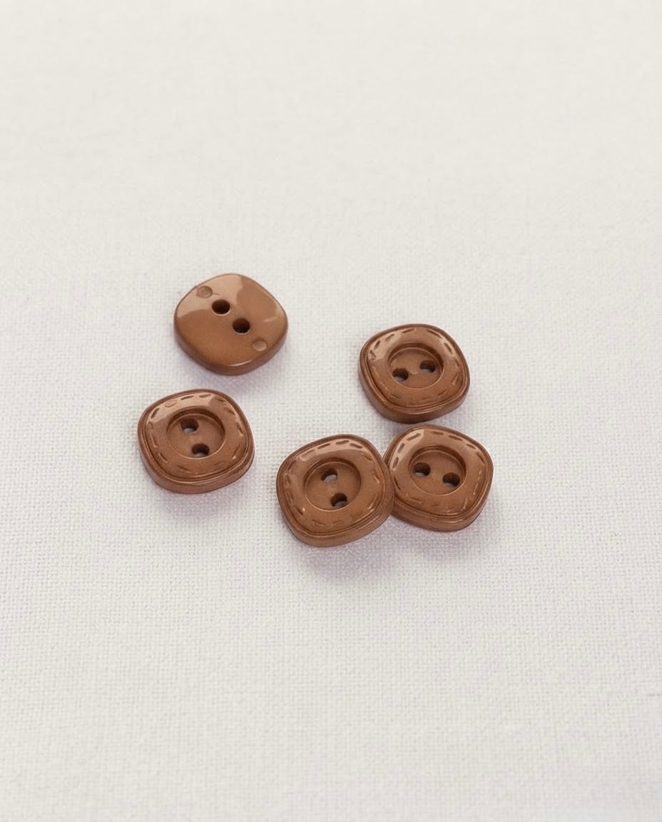 Boutons carrés marron brillants de 14 mm à 2 trous posés sur une toile écrue, dont un vu de dos