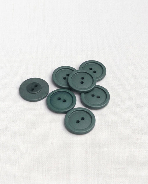 Sept boutons ronds mats bleu pétrole tirant sur le vert de gris, 19 mm, 2 trous, avec un rebord, dont un vu de dos