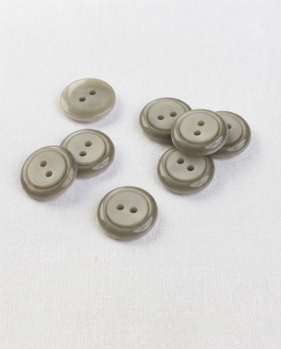 Boutons ronds gris vert de 13 mm à 2 trous, bord bombé brillant et centre mat plus clair, dont un vu de dos
