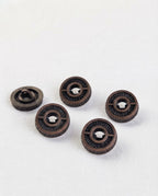 Boutons effet bronze sombre de 15 mm vus de biais, tranche perlée et face gravée, un bouton retourné montre sa queue