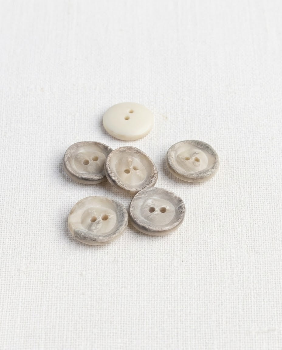 Six boutons ronds effet corne de 16 mm à 2 trous, centre crème et bord marbré gris brun texturé, dont un vu de dos crème