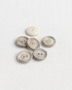 Six boutons ronds effet corne de 16 mm à 2 trous, centre crème et bord marbré gris brun texturé, dont un vu de dos crème