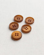 Boutons caramel ambré de 15 mm à 4 trous vus de biais, un bouton retourné montrant le dos lisse