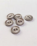 Six boutons ronds gris taupe brillants de 14 mm à 2 trous, cerclés d'un anneau blanc, vus de biais