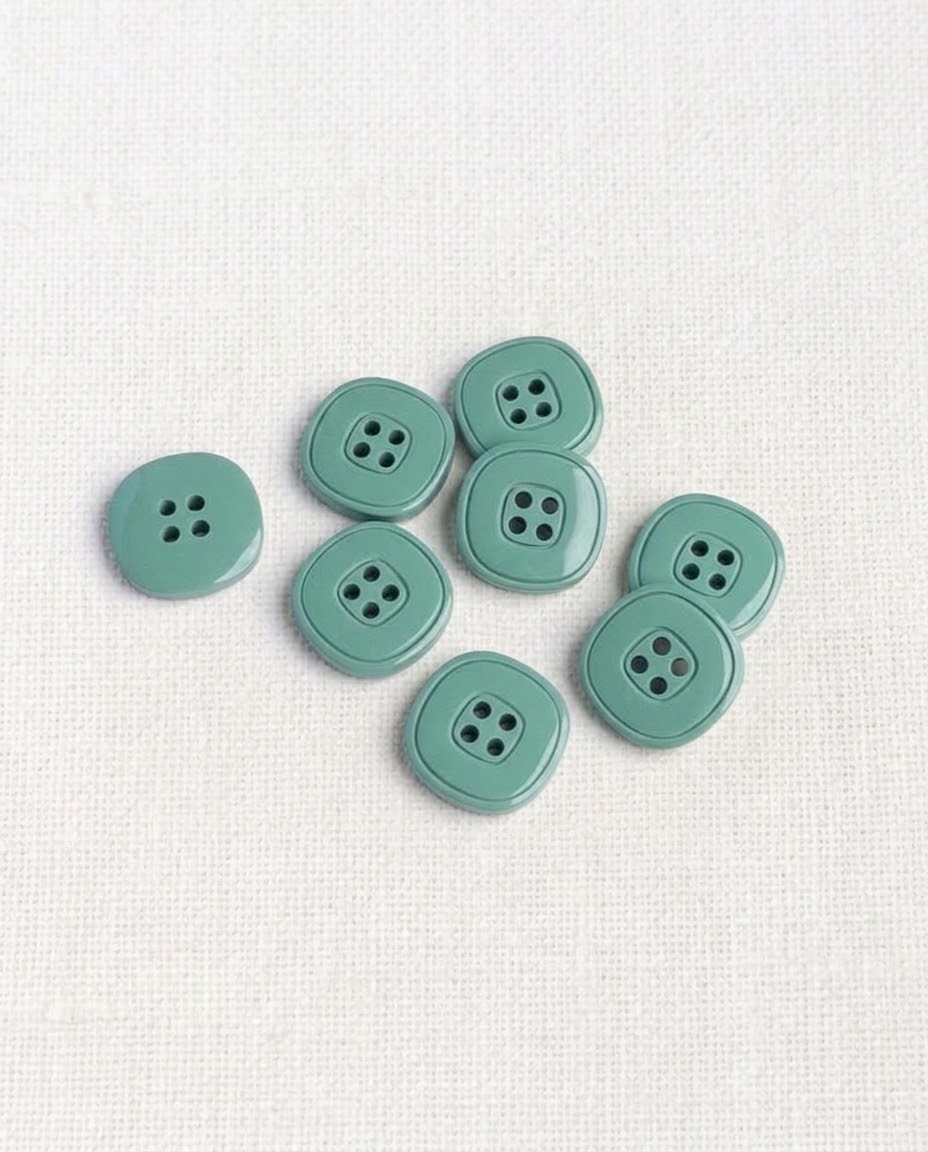 Huit boutons carrés vert de gris de 17 mm à 4 trous, angles arrondis, dont un vu de dos