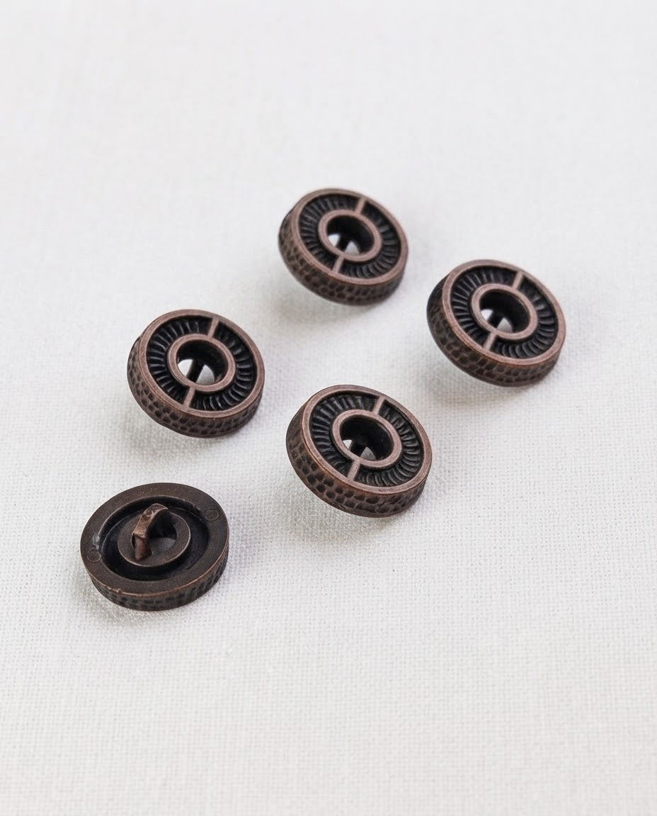 Cinq boutons ronds effet bronze patiné de 15 mm à queue, gravés de rayons autour d'un centre en creux, dont un vu de dos