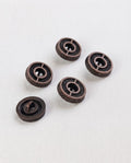 Cinq boutons ronds effet bronze patiné de 15 mm à queue, gravés de rayons autour d'un centre en creux, dont un vu de dos