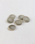 Six boutons ronds beige grisé mat de 17 mm à 2 trous, centre creusé cerné de deux cercles, dont un vu de dos