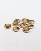 Boutons effet corne et doré de 12 mm à 2 trous vus de biais, le cercle doré forme un fin rebord
