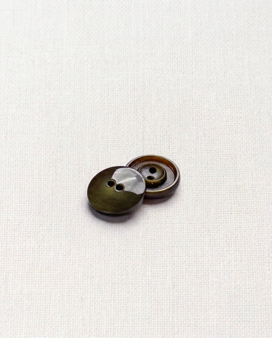 Deux boutons ronds vert olive de 15 mm à 2 trous posés l'un sur l'autre, dont un vu de dos