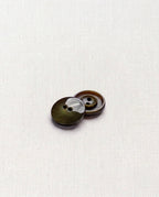 Deux boutons ronds vert olive de 15 mm à 2 trous posés l'un sur l'autre, dont un vu de dos