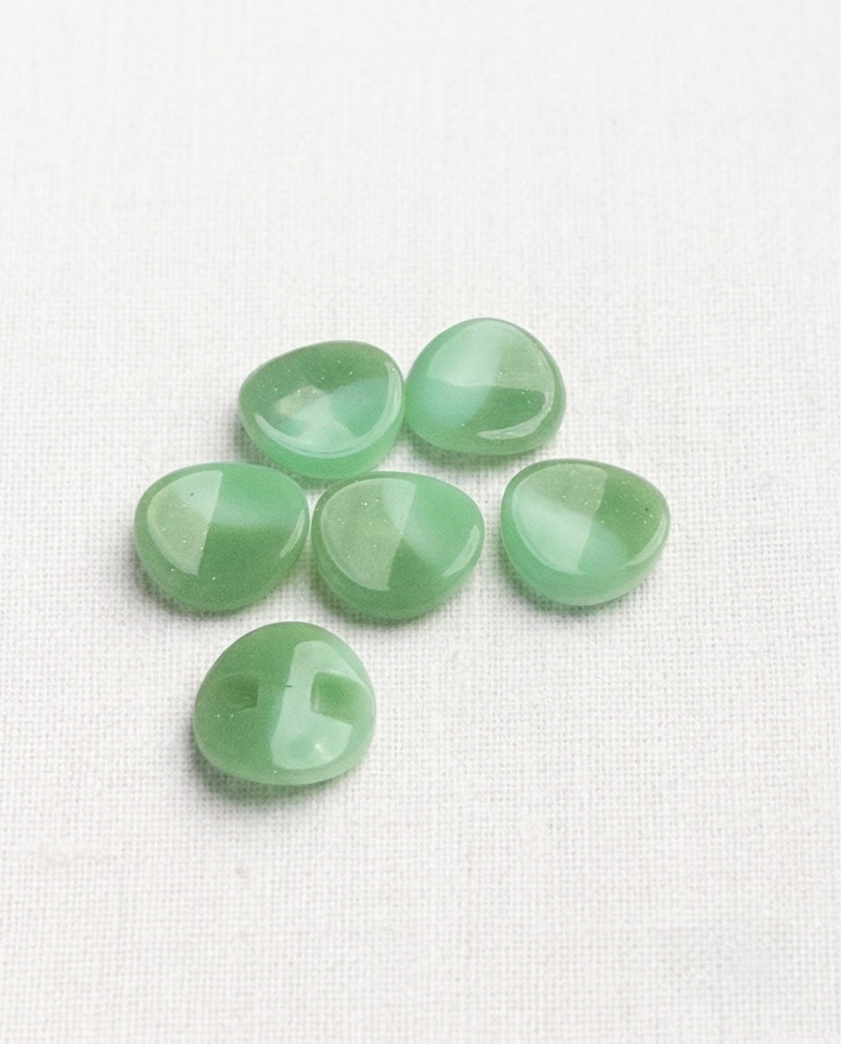 Six boutons vert amande marbré de blanc, 15 mm, bord ondulé, dont un retourné qui montre sa queue encastrée