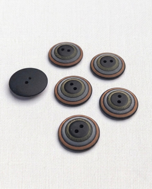 Six boutons ronds de 23 mm à 2 trous, à cercles concentriques noir, kaki, gris et cuivre, dont un vu de dos noir mat