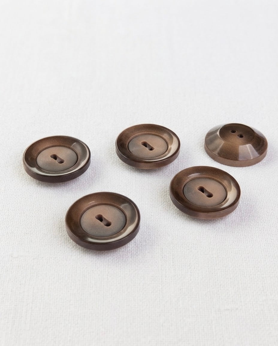 Cinq gros boutons marron de 22 mm à 2 trous, dont un retourné qui montre son dos bombé