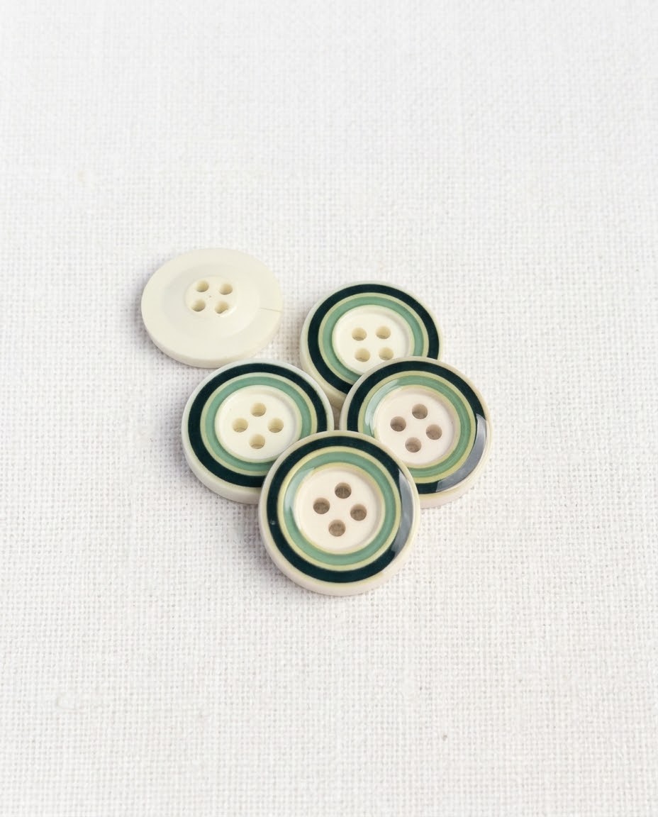 Cinq boutons ronds de 22 mm à 4 trous, fond crème et cercles vert foncé et vert d'eau, dont un vu de dos crème uni