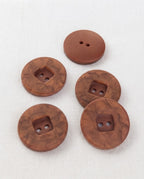 Cinq gros boutons ronds effet bois de bruyère de 22 mm à 2 trous, anneau marbré et centre carré en creux, dont un vu de dos