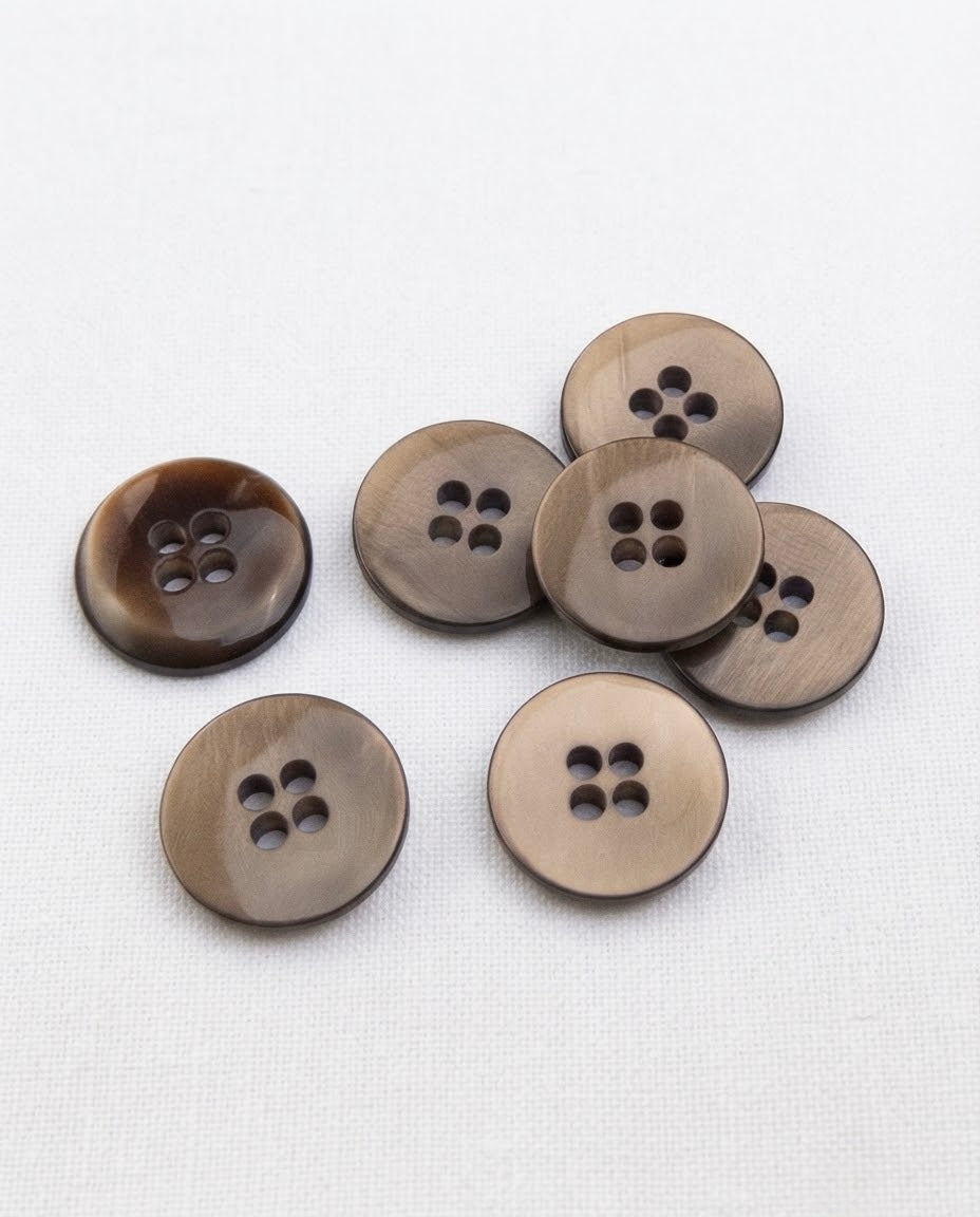 Sept boutons ronds taupe à reflets de 18 mm à 4 trous, dont un vu de dos