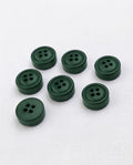 Sept boutons ronds épais vert sapin de 18 mm à 4 trous, centre creusé entouré d'un rebord, dont un vu de dos